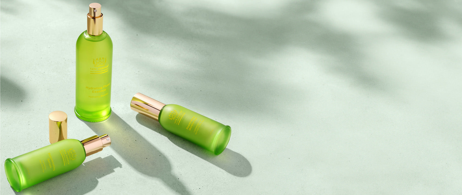 Green skincare bottles on a light green background with shadow.
